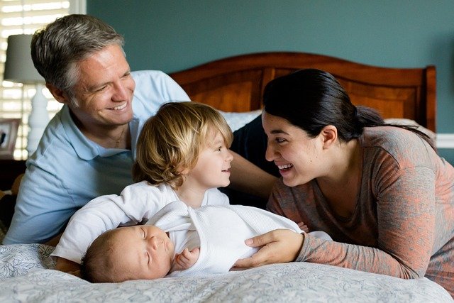 <src-image2='' father and mother playing with their kids at bedtime''/>